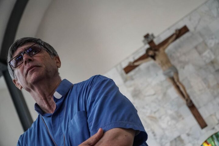 Un uomo consegna un proiettile a don Patriciello durante la messa a Caivano